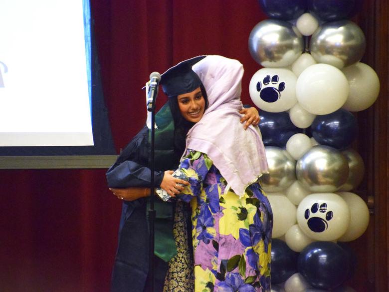 Two Penn State Abington (near Philadelphia) students hugging at cultural graduation 